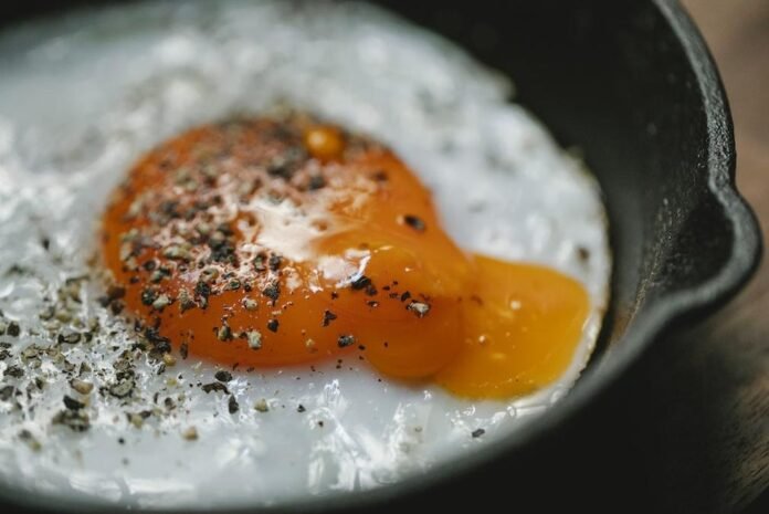 Fried egg with condiment in frying pan